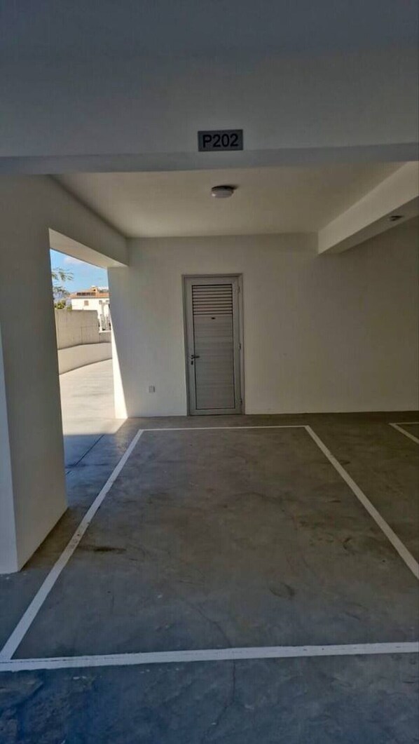 A parking garage with a door marked 'P202' and a clear view of the parking lot.