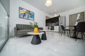 A modern living room with a grey sofa, a yellow vase, and a painting on the wall.