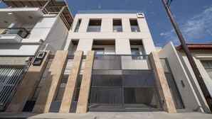 A modern building with a gated entrance, multiple windows, and a flat roof. - New deluxe studio in the heart of Limassol (Limassol)