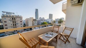 Ein Balkon mit Holzmöbeln, einem Tisch und Stühlen.
