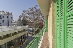 A balcony with green shutters overlooking a street with buildings and trees. - Private room in shared flat (Nicosia)