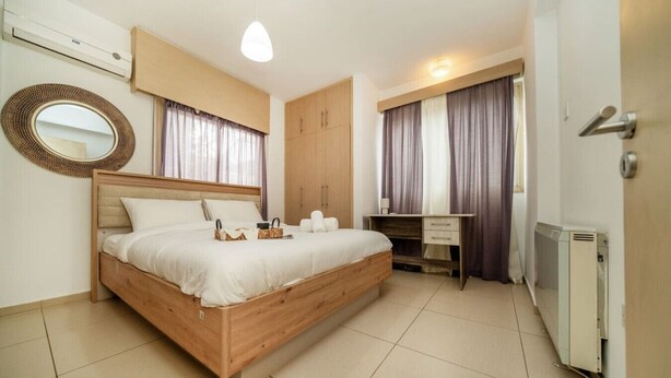 A bedroom with a wooden bed, a desk, a wardrobe, and a radiator. - 3 bedroom flat near center (Nicosia)