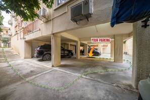 Eine Parkgarage mit zwei Autos unter einem Gebäude.