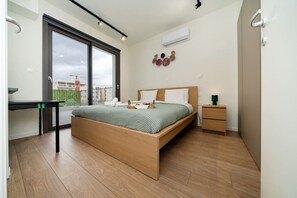 Ein Schlafzimmer mit Bett, Nachttisch und Schreibtisch mit Stuhl.