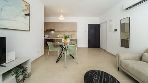 Eine moderne Wohnung mit Essbereich, Küchenzeile und Wohnbereich.