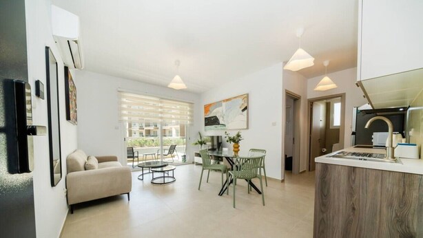 Ein modernes Apartment mit Wohnzimmer, Essbereich und Küchenzeile.