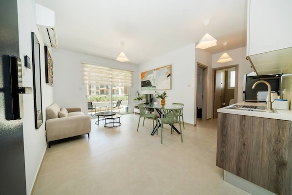 Un appartement moderne comprenant un salon, un coin repas et une kitchenette.
