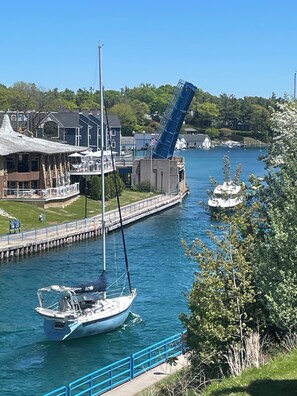 Ein Anwesen am Wasserufer mit Anlegesteg, Segelboot und Brücke.