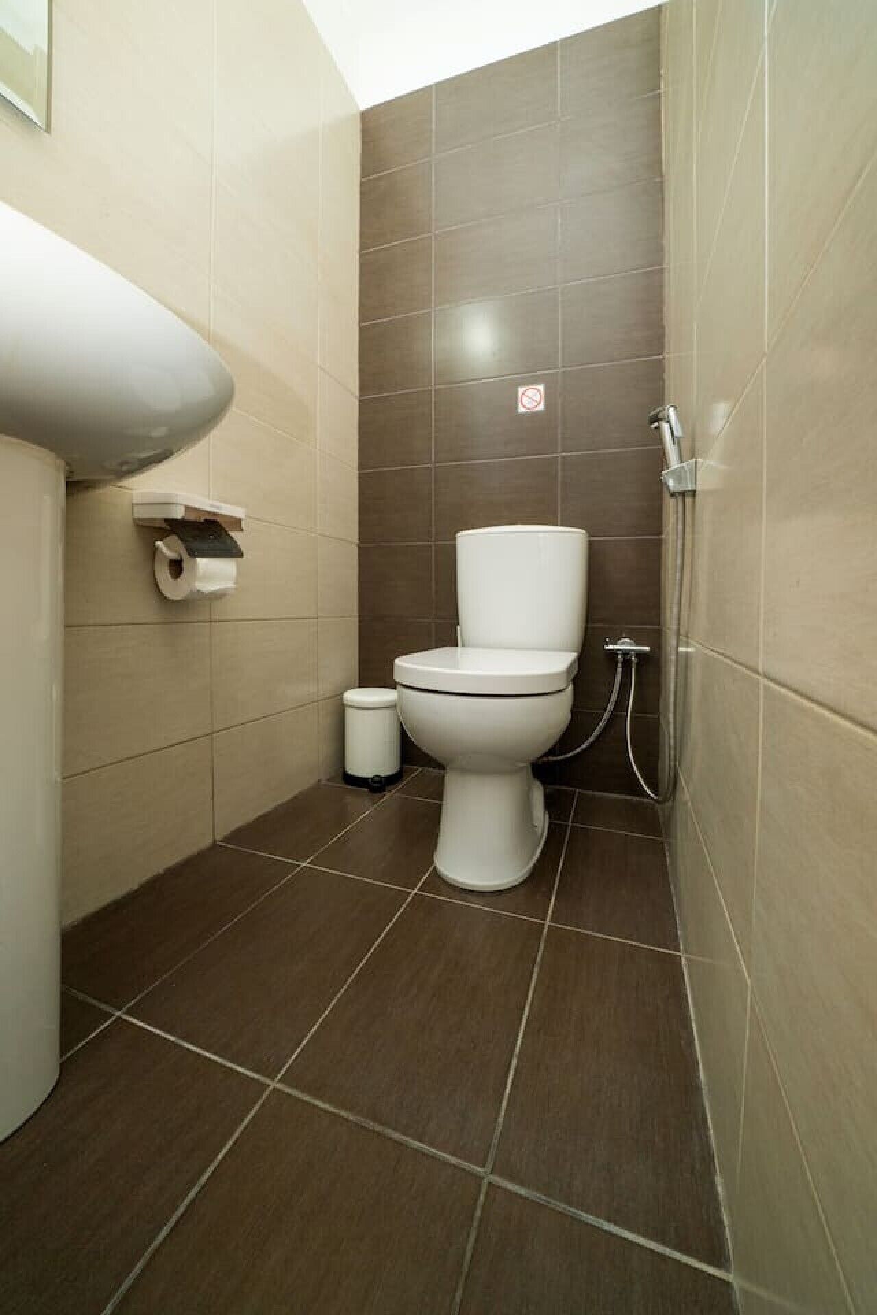 Une salle de bain avec des toilettes, un lavabo et une douche.
