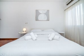 Ein Hotelzimmer mit einem Bett, zwei Nachttischen, einer Lampe und einem Bild an der Wand.