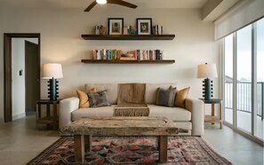 A living room with a sofa, coffee table, and bookshelves. - Lujoso Penthouse frente al mar - Piscina privada (Puerto Vallarta)