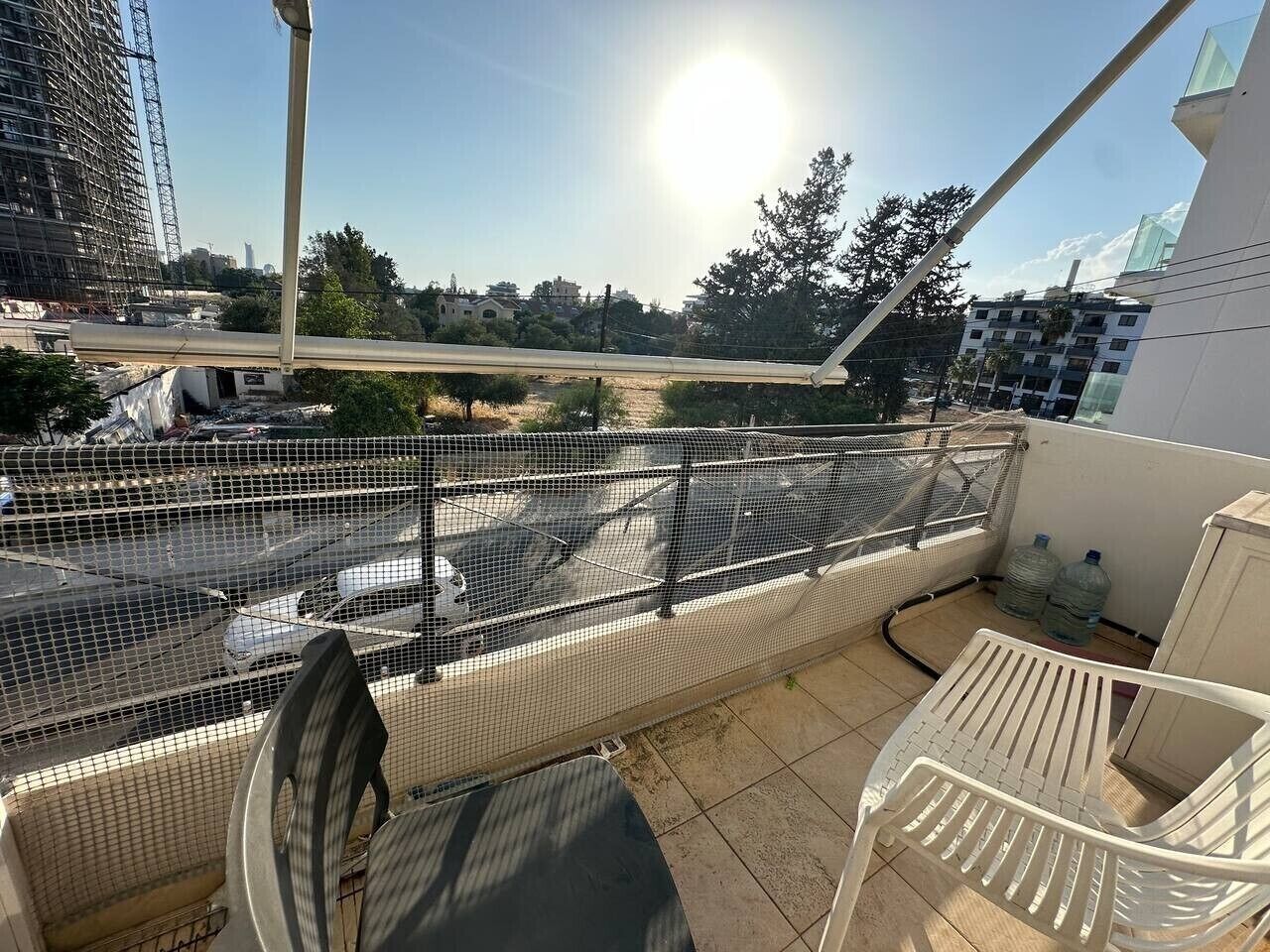 En balkon med gelænder, en stol og et bord.