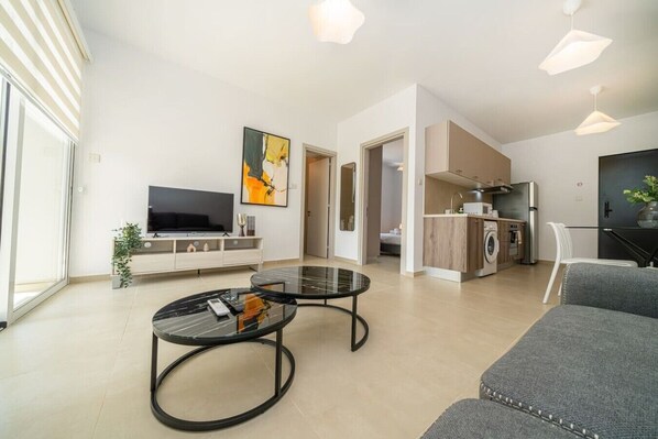 A modern apartment with a living room, kitchen, and dining area.