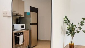 Et spejl viser et køkken med mikrobølgeovn, ovn og køleskab.