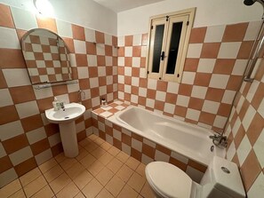 A bathroom with a sink, bathtub, toilet, and a mirror. - 2 bedroom flat in center (Nicosia)