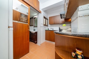A kitchen with wooden cabinets, a white sink, and a countertop with a bowl.
