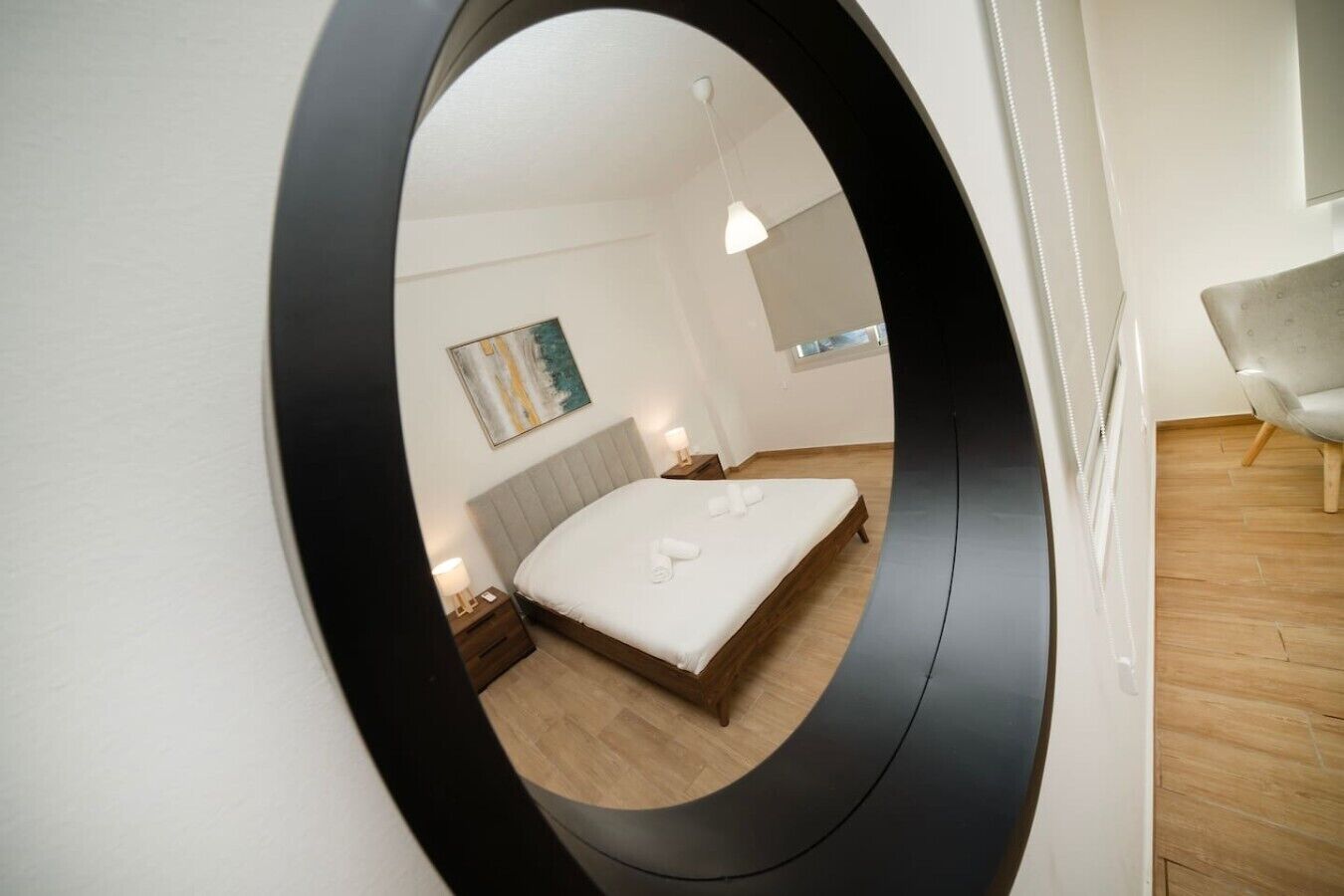 Ein Schlafzimmer mit einem Bett, einem Nachttisch, einer Lampe und einem Bild an der Wand.
