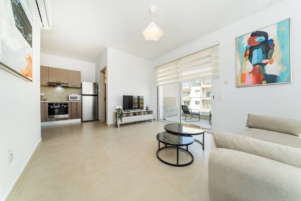 A modern apartment with a kitchen, dining area, and living room.