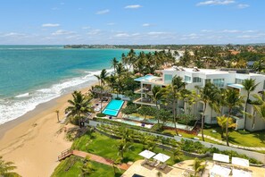 A beachfront hotel with a pool, palm trees, and ocean views. - Beachfront Luxury Studio • Ultravioleta Cabarete (Cabarete)