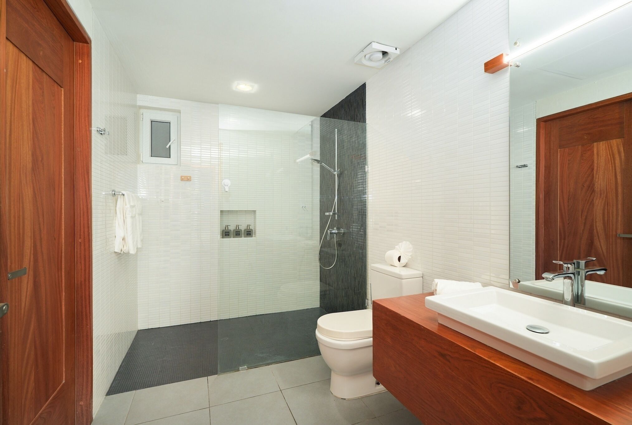 Un baño moderno con ducha, inodoro y lavabo.