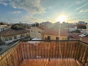 A balcony with a view of a cityscape during sunset. - 1 bedroom flat, historic center (Limassol)