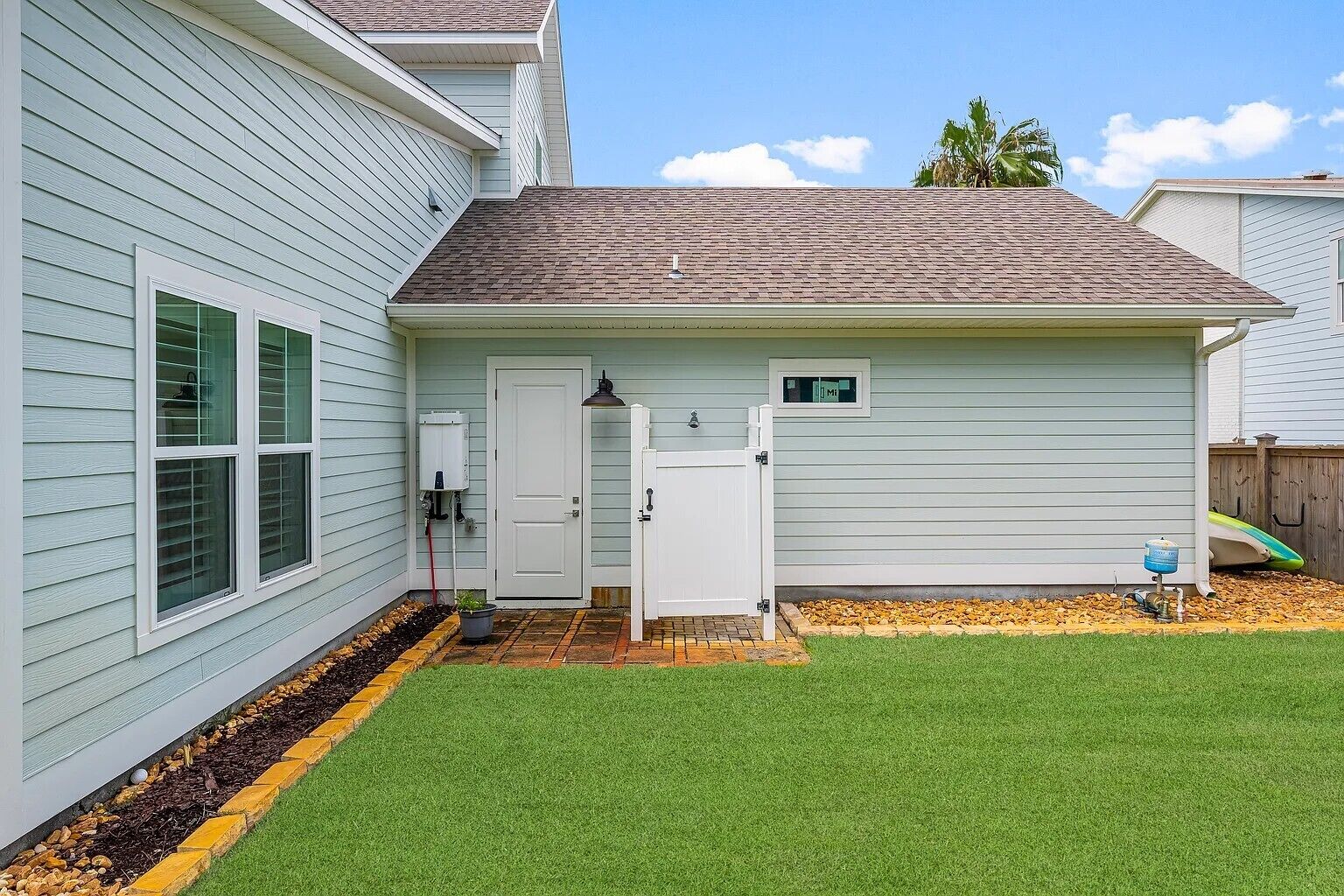 A house with a front yard, a door, a mailbox, and a small shed.