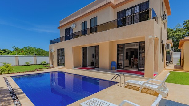 A modern two-story house with a swimming pool, outdoor seating, and a balcony. - 2 or 3 Bedroom - A&E Residence  (Kwale County)