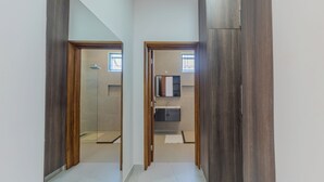 A hallway leading to a bathroom with a mirror, a sink, and a towel rack. - 2 or 3 Bedroom - A&E Residence  (Kwale County)