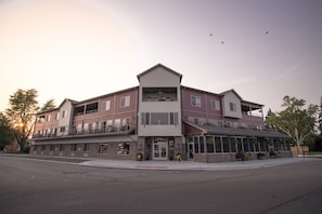 A multi-story hotel with a central entrance, balconies, and large windows.