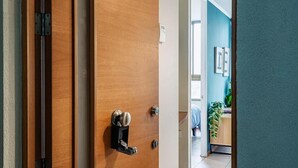 A wooden door with a modern handle, a visible lock, and a small shelf. - Rbk Moderno dpto ubicación inmejorable (Santiago)