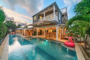 A two-story house with a swimming pool, outdoor seating, and a swan float. - Retro Designer Bungalow 200' from Beach w/ VW Bus Grill & Pool (Harbour Island)