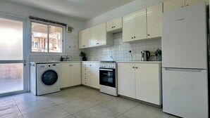 A kitchen with a washing machine, oven, refrigerator, and cabinets. - 2 bedrooms flat near center (Egkomi)