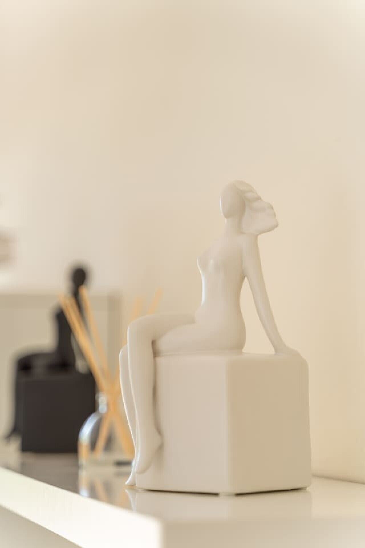 Une sculpture blanche et abstraite, posée sur un piédestal.
