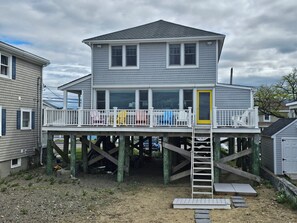 A two-story house with a balcony, a yellow door, and a wooden deck. - The Beach House, Crescent Beach, Hull (Hull)