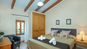 A bedroom with a bed, a wooden wardrobe, a desk with a chair, a window with curtains, and a lamp. - Spacious Countryside Villa, A/C Private Pool, Mountain Views in the Desirable Area of La Font! (Pollença)