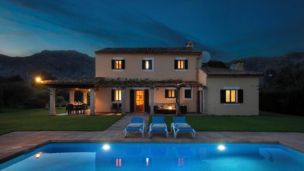 A two-story house with a swimming pool in front, a patio with chairs, and a view of the mountains. - Spacious Countryside Villa, A/C Private Pool, Mountain Views in the Desirable Area of La Font! (Pollença)