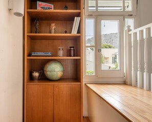 Ein Holzregal mit verschiedenen Gegenständen, darunter ein Globus, Bücher und Dekorationsobjekte.