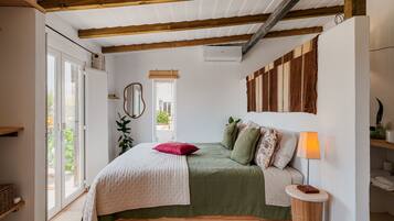 A bedroom with a bed, bedside lamp, and a window.
