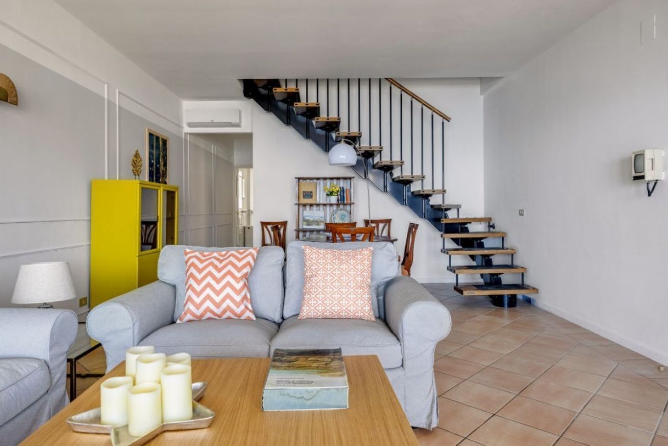 A living room with a sofa, coffee table, and a staircase.