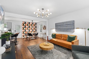 Ein modernes Wohnzimmer mit Sofa, Couchtisch und Essbereich.