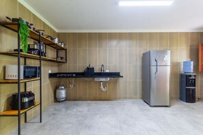 A kitchen with a microwave, stove, sink, and refrigerator. - Casa com piscina pertinho da Praia do Boqueirão (Japaratinga)