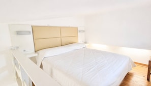 A bed with a headboard, bedside tables, and a wooden floor. - Bicorna Chania Pool Escape - Yellow Room 1 (Apokoronas)