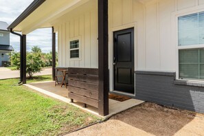 A house with a porch, a door, and a window. - 3-bedroom Townhome with High Speed WIFI (Bullard)