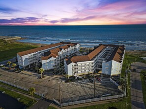 Ein Hotel an der Küste mit mehreren Gebäuden, einem Parkplatz und Meerblick.