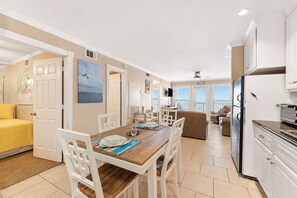 Ein helles, offenes Wohnzimmer mit Essbereich, Küche und Meerblick.