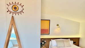 A bedroom with a bed, bedside table, lamp, and a wall art piece. - The Genoese Galata (İstanbul)