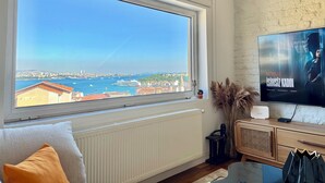 A room with a large window, a television, and a radiator. - The Genoese Galata (İstanbul)