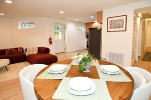 A dining area with a round table, white plates, and a potted plant. - 2 Bedroom 2 Bathroom Walker and Transit Paradise on H Street Corridor (Washington)