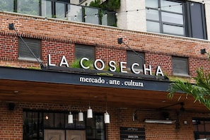 Ein Backsteinhaus mit der Aufschrift 'LA COSECHA' und darunter den Worten 'mercado. arte. cultura'.