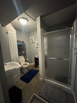 Ein Badezimmer mit Dusche, Toilette und Waschbecken.